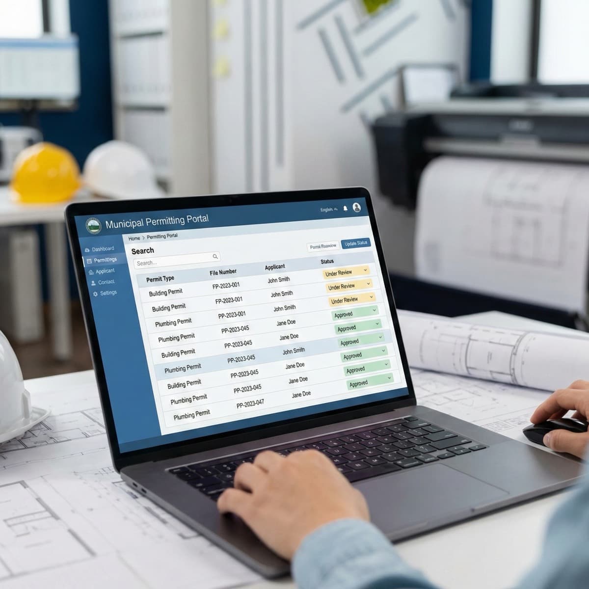 A laptop screen showing a work for Permit Application Tracking in a home office