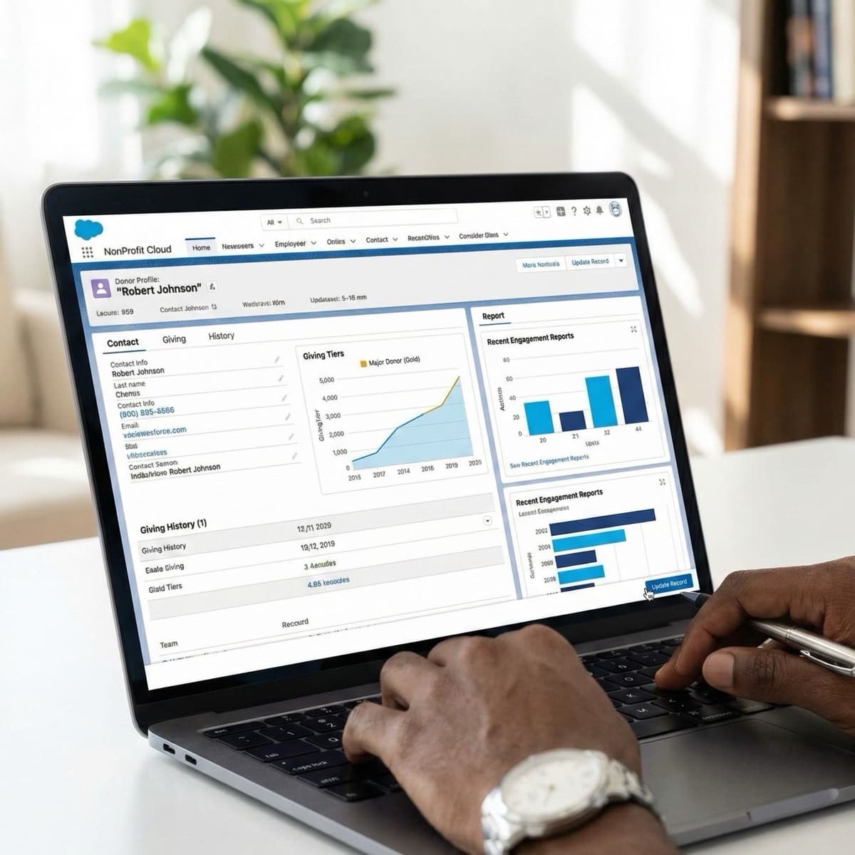 A laptop screen showing a work for Donor Database Management CRM in a home office